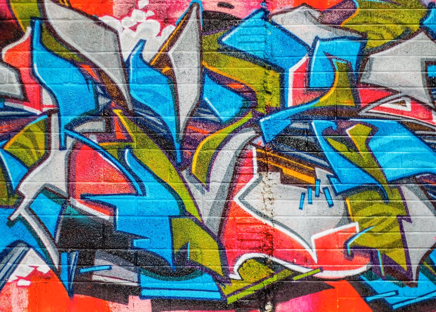 Colourful Graffiti Mural on a Brick Wall Featuring Abstract Shapes