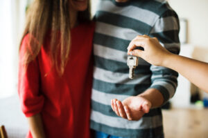 A man gives a woman a key to a house, symbolising new beginnings.