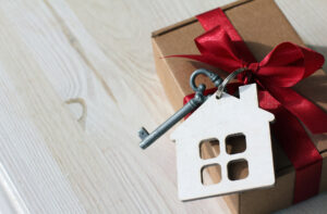 a small house shaped key with a red bow