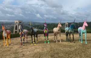 a group of horses standing on top of a hill