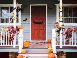 Halloween decorations adorn a porch with pumpkins and cobwebs.