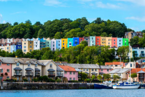 A row of vibrant houses nestled on a green hillside.