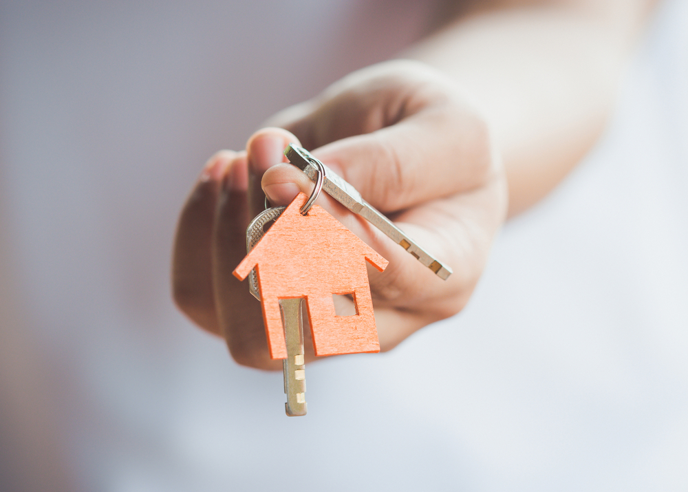 a woman holding a house key in her hand
