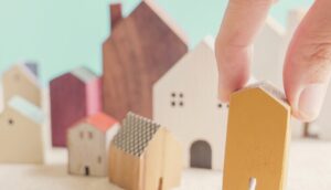 a person placing a house on top of a pile of paper