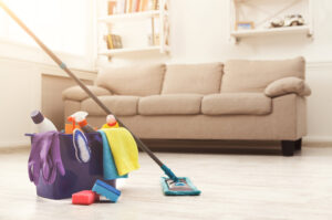 a woman cleaning a living room with a mop