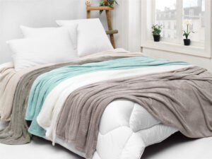 a white bed with a blanket on it