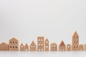 Wooden toy houses arranged on a white background.
