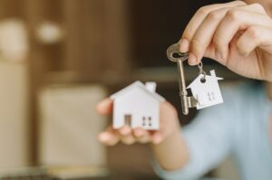 A person holding a key, symbolising access to a new home.