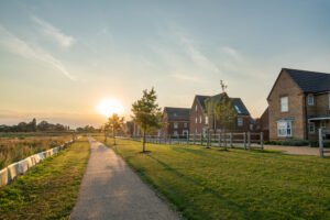 Pathway leading to houses, illuminated by a warm sunset glow.