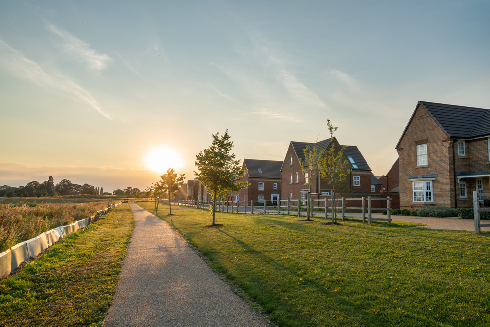 Pathway leading to houses, illuminated by a warm sunset glow.