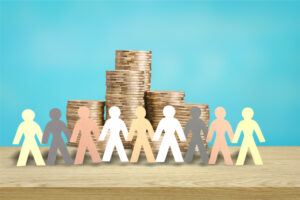 A stack of coins with a group of people standing before it.