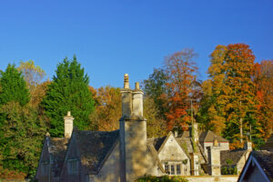 Large house featuring a prominent chimney against a clear sky.
