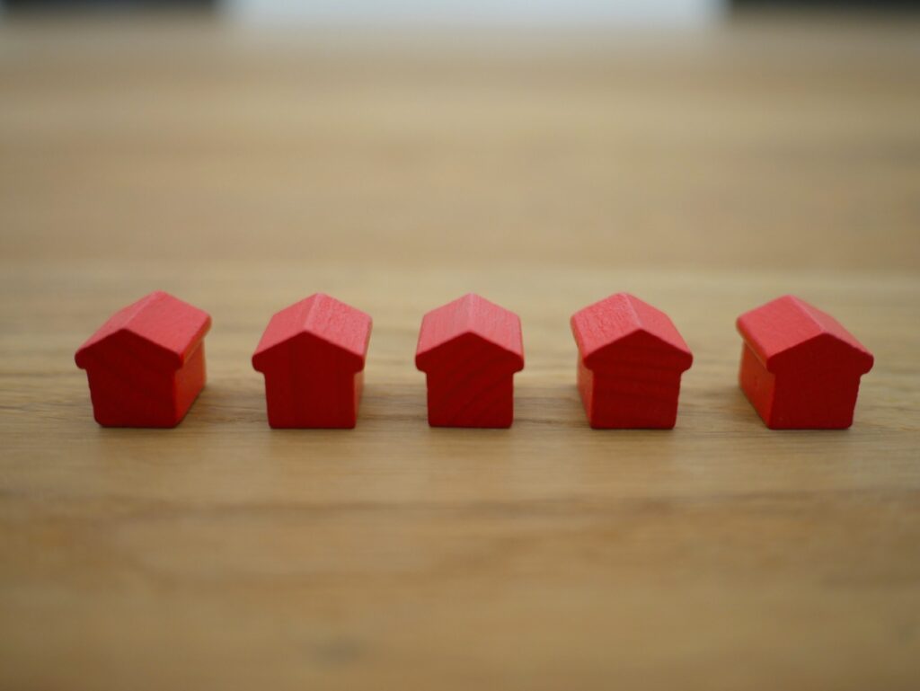 Row of red houses displayed on a wooden table.
