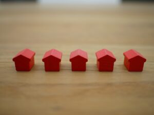 Row of red houses displayed on a wooden table.