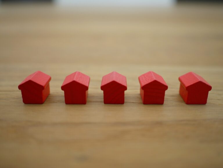 Row of red houses displayed on a wooden table.