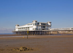 Large white building situated on a sandy beach.