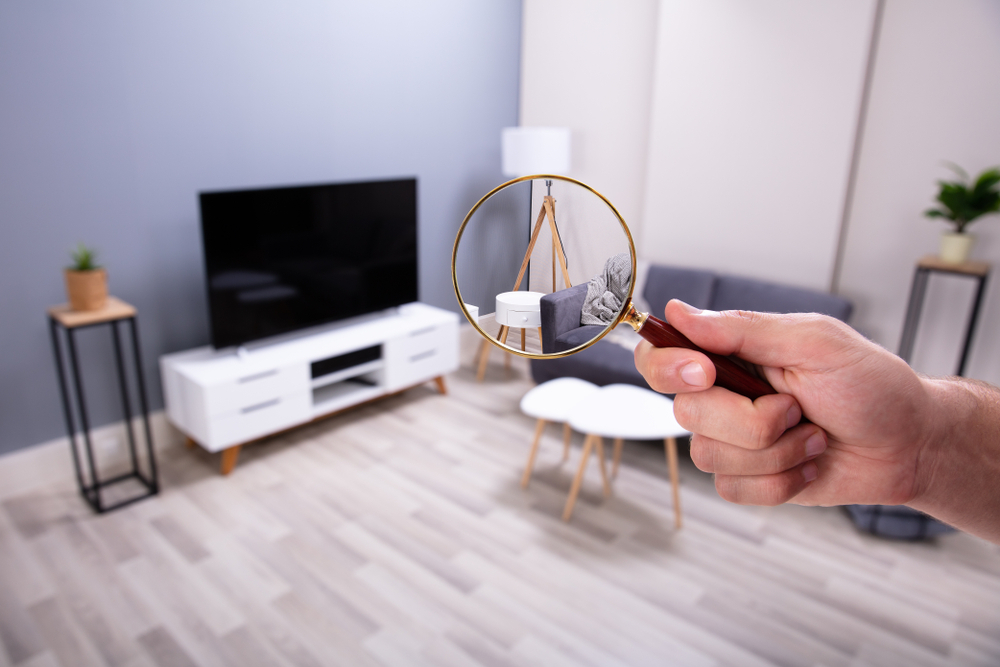 Person examining a television with a magnifying glass.