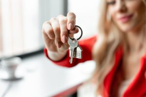 A woman holding a key, symbolising access to a new home.